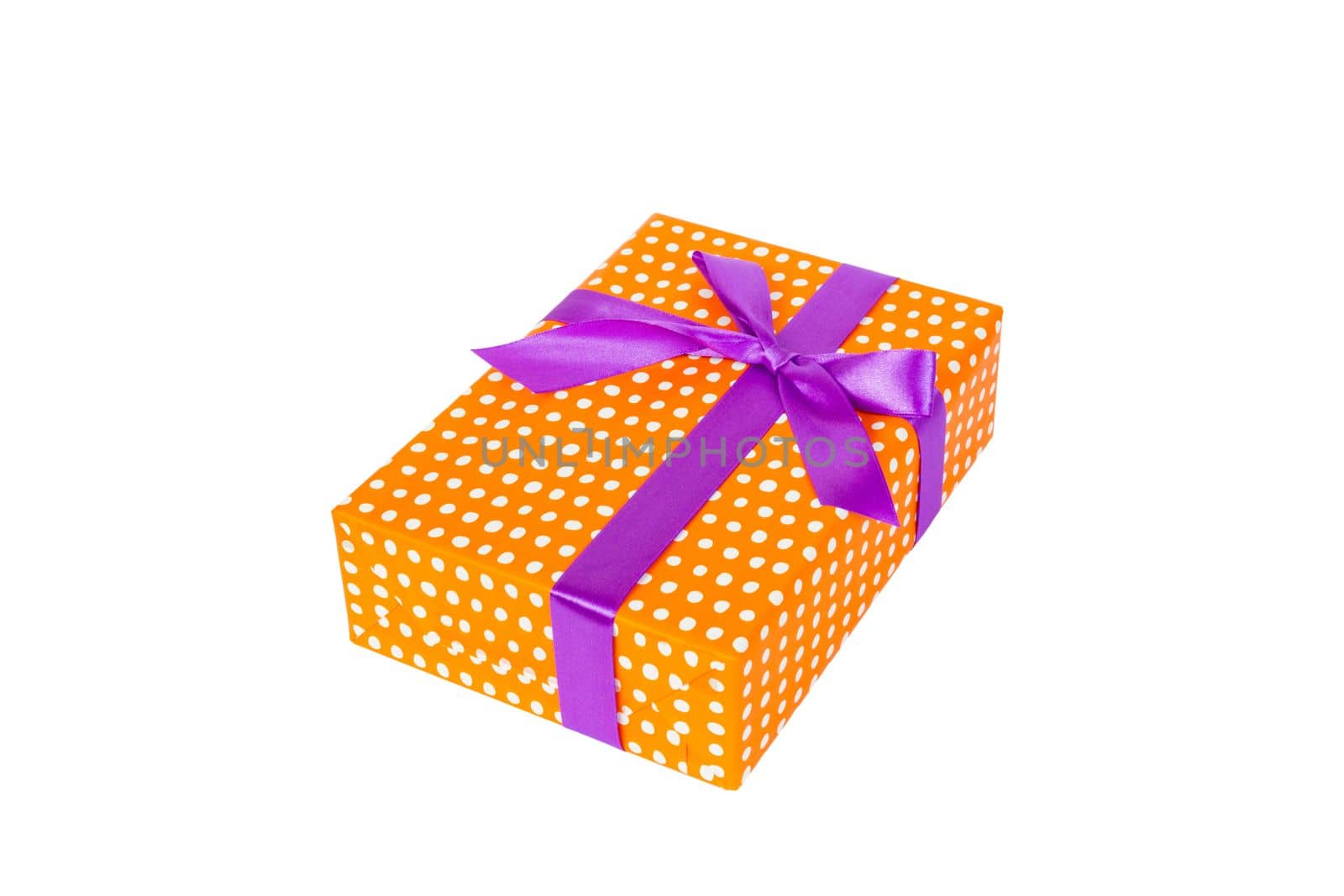 Christmas or other holiday handmade present in orange paper with purple ribbon. Isolated on white background, top view. thanksgiving Gift box concept.