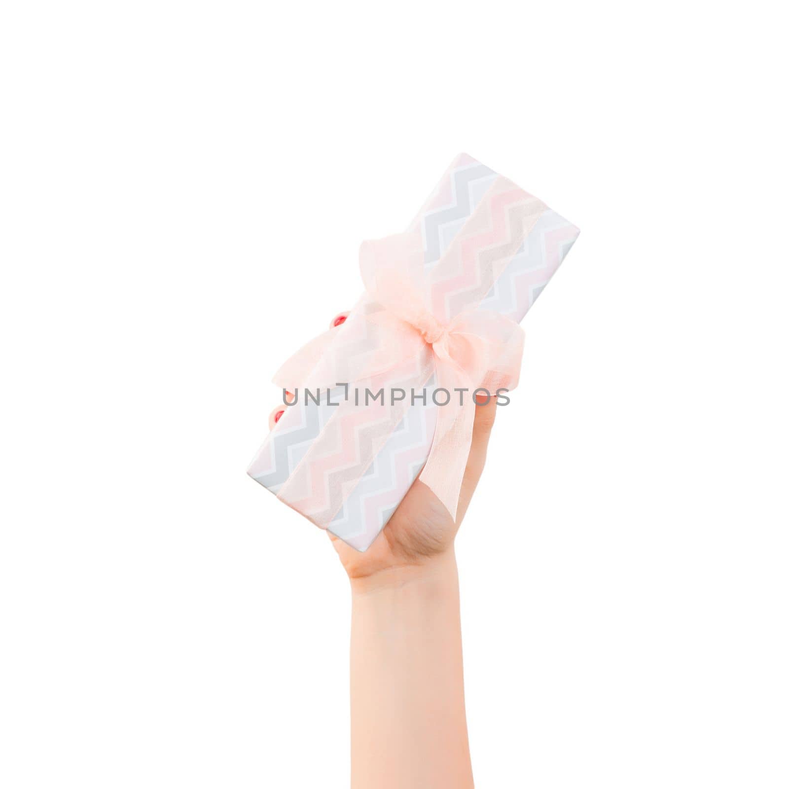 Woman hands give wrapped Christmas or other holiday handmade present in colored paper with orange ribbon. Isolated on white background, top view. thanksgiving Gift box concept.