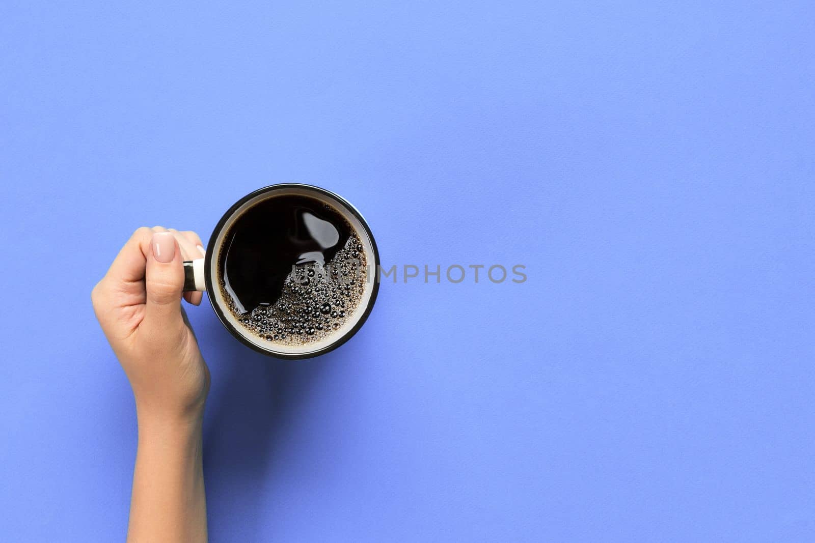 High angle of woman hands holding coffee mug on purple background Minimalistic style. Flat lay, top view isolated.