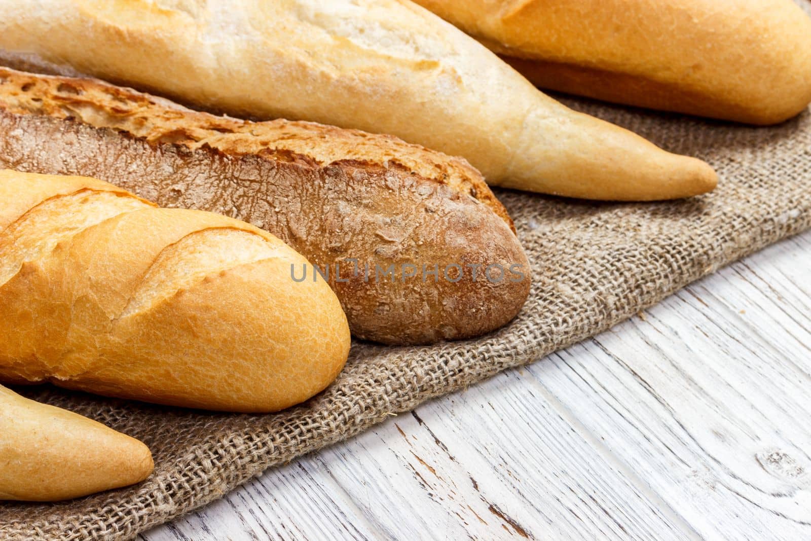 different types of baguette on a wooden background.