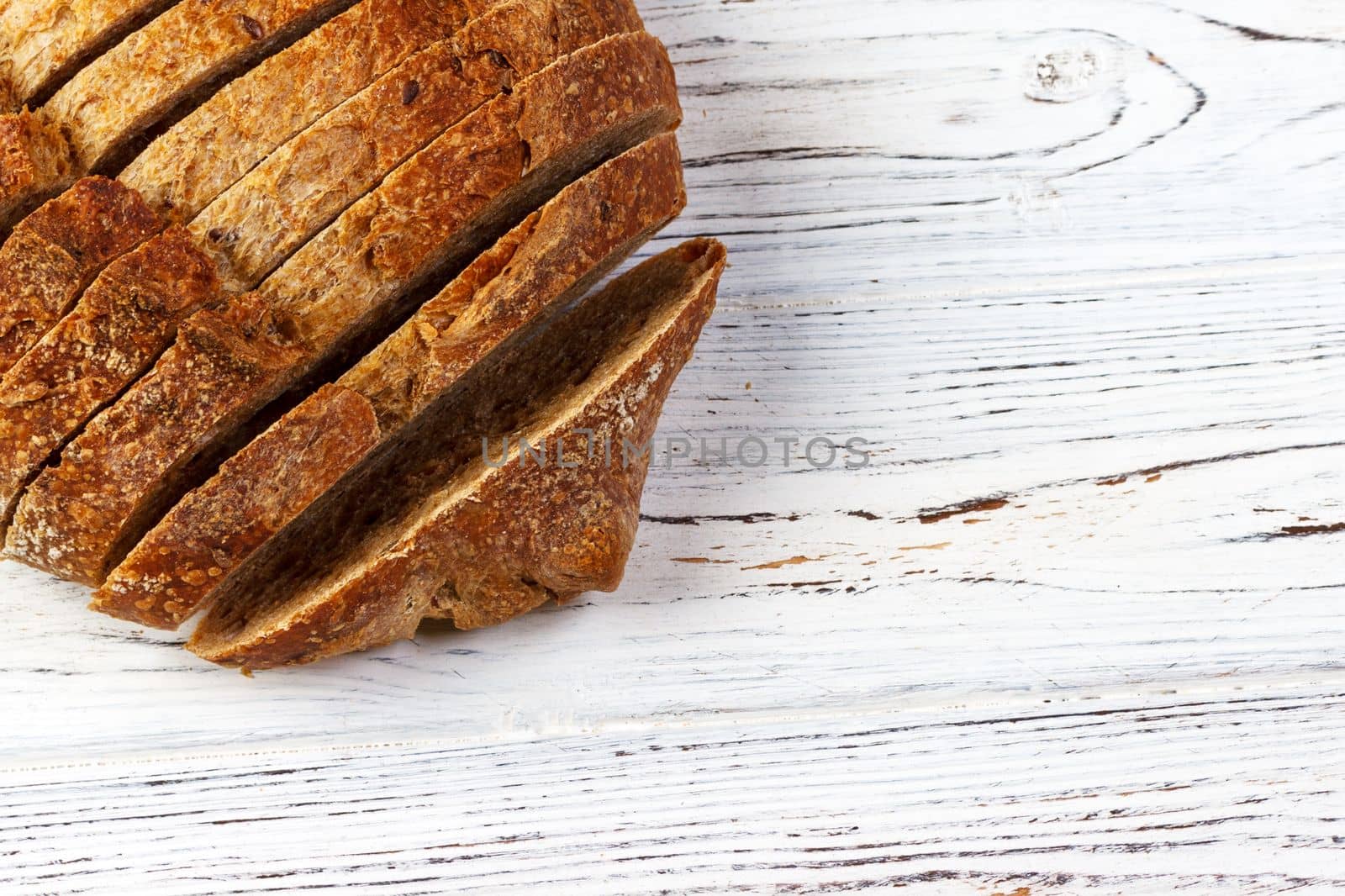 French loaf sliced, on a wooden board with space for text.