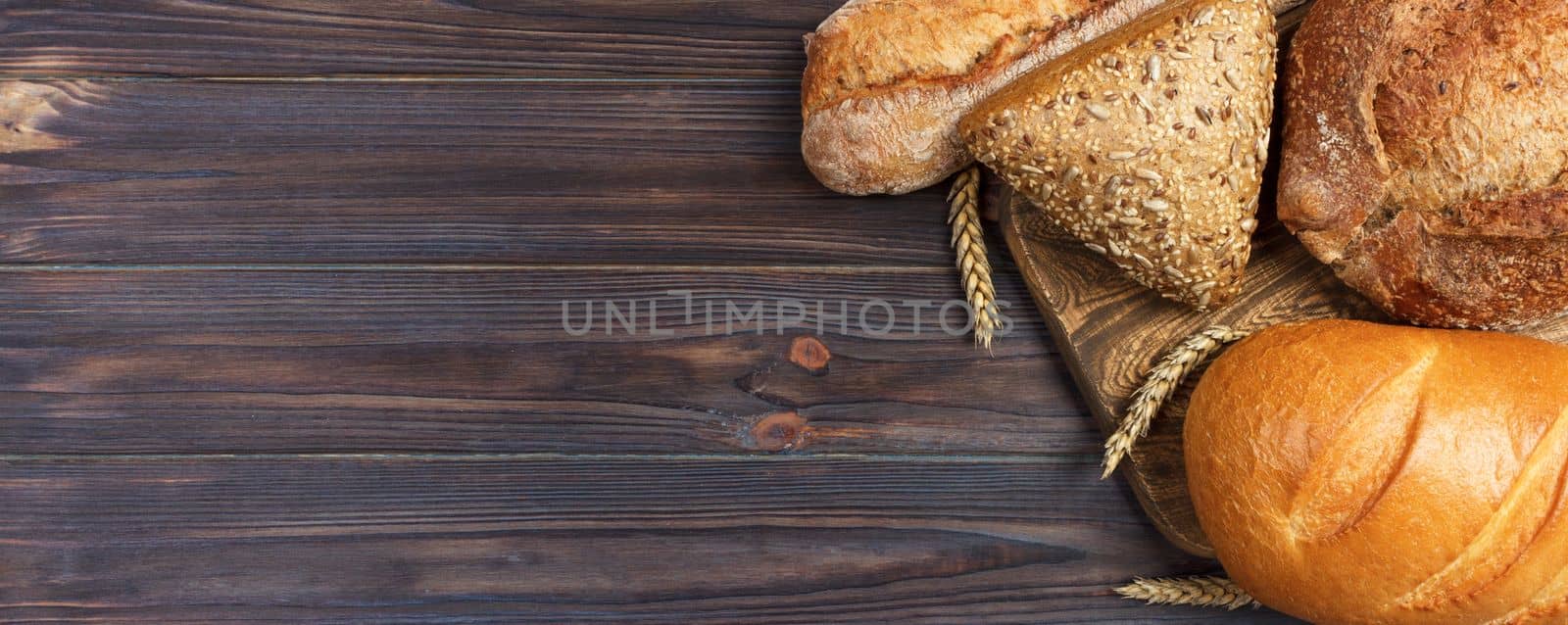 Homemade loaf of wheat bread baked on wooden background. banner for advertising and design, promo top view with copy space.