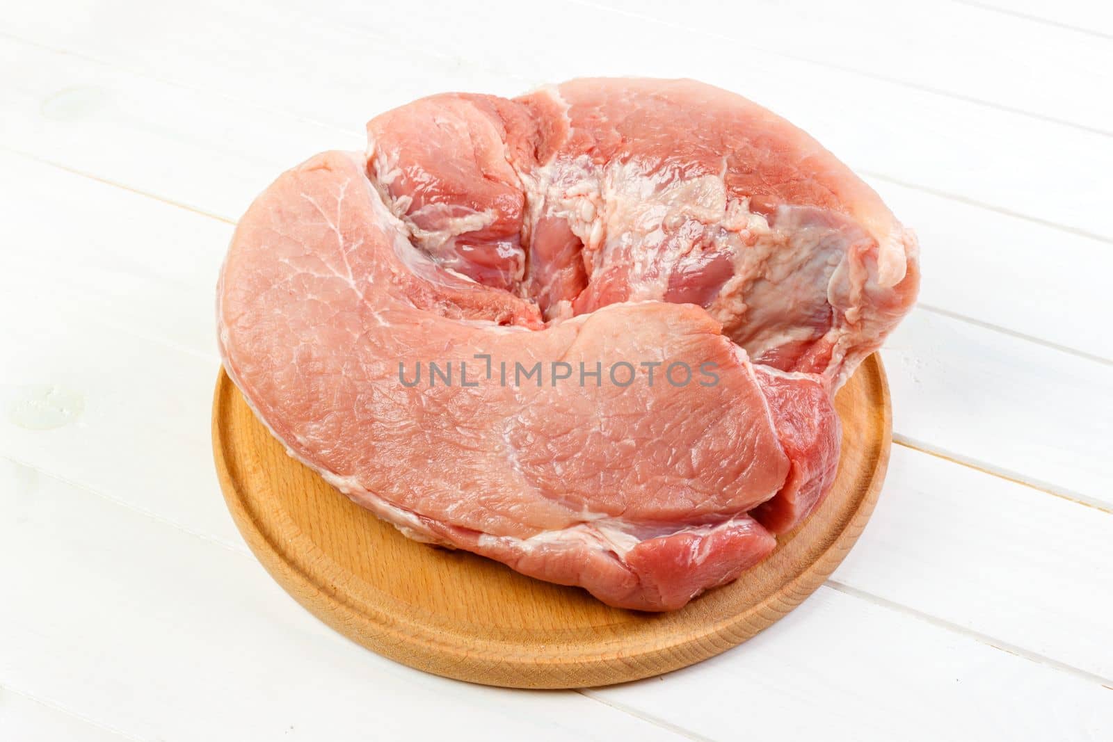 Fresh pork on a cutting board ready to cook. pork meat on white wooden background.