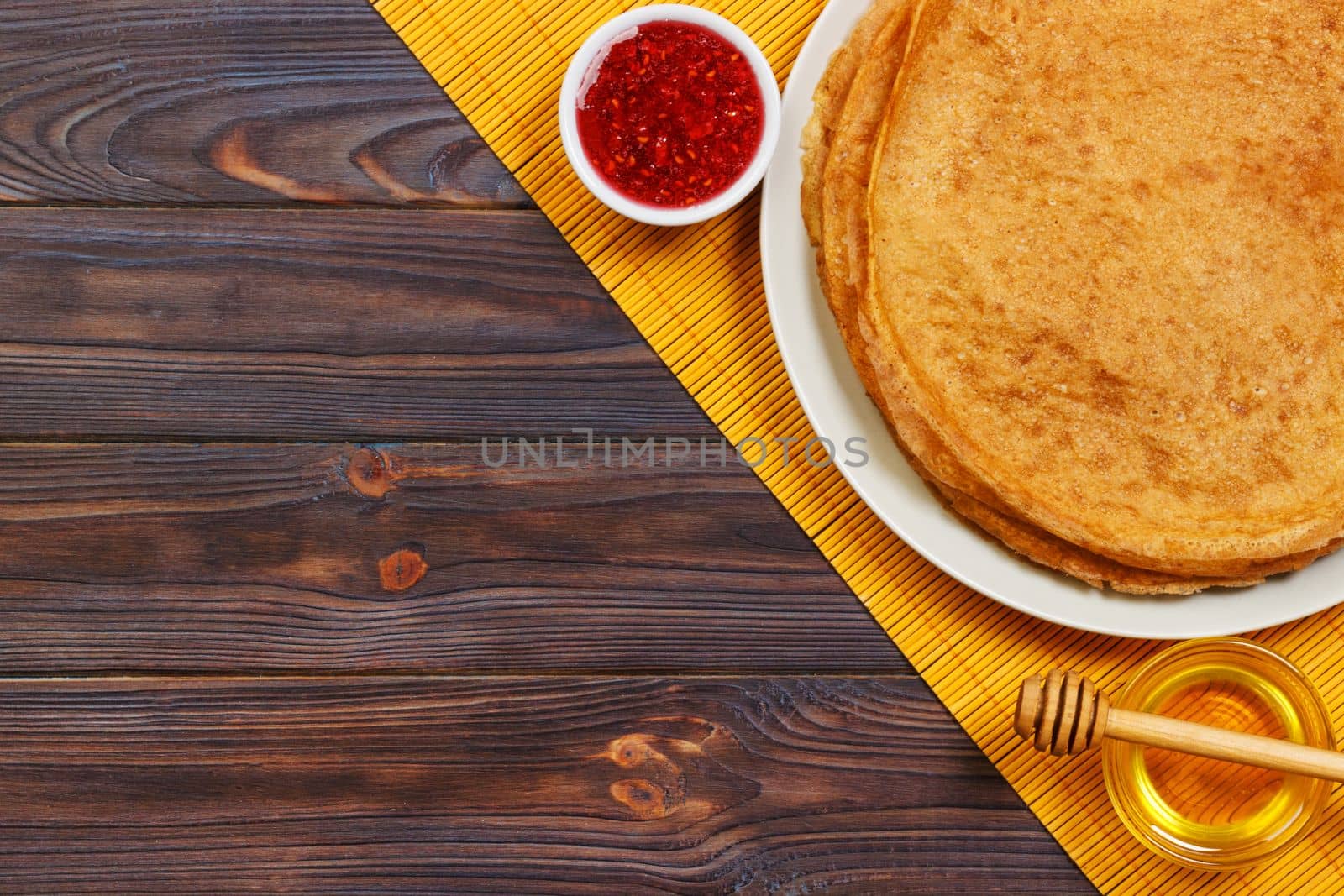 Hot pancakes with sprinkled maple syrup and raspberry jam. The good you breakfast. top view.