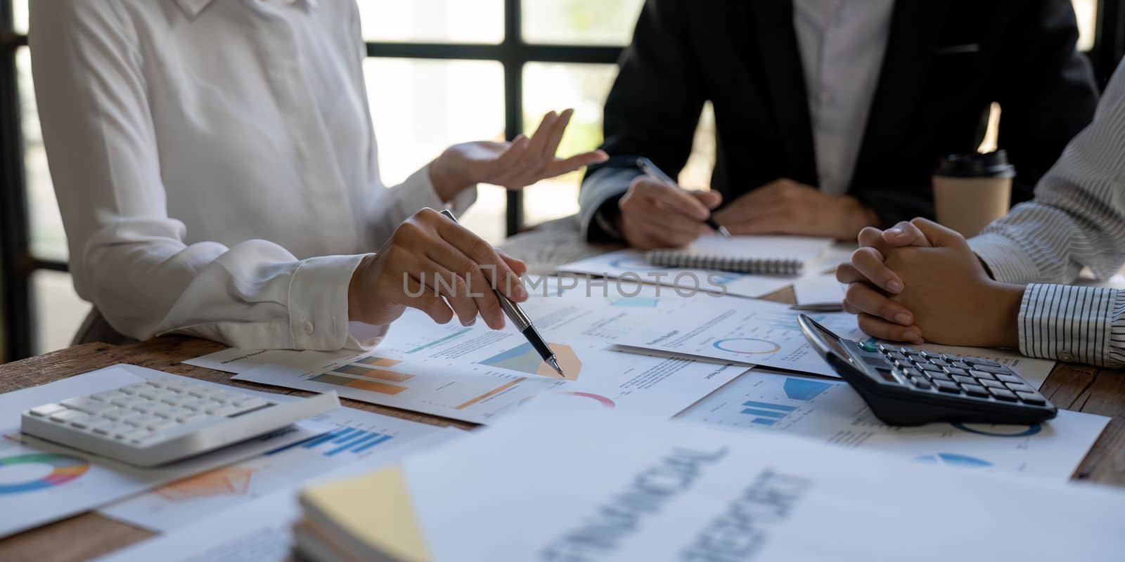 Business team finance or bookkeeper working with a calculator to calculate business data summary report, accountancy document and laptop computer at the office, business meeting concept.