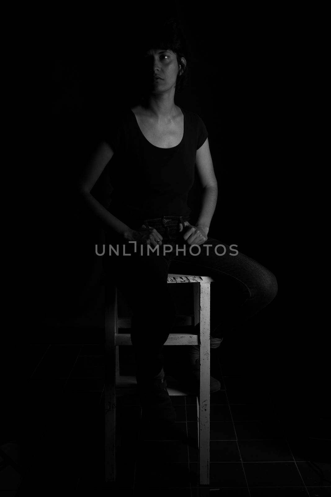 Black and white portrait of a girl sitting on a stool