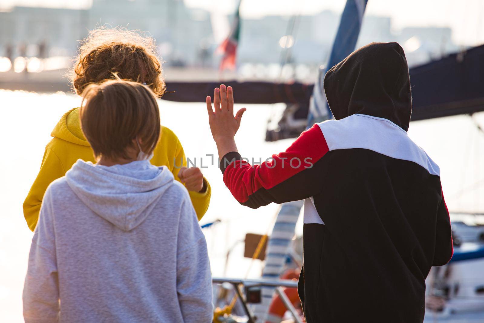 Trieste, Italy - October, 10: Young boys playing clapping hands next to the sea on October 10, 2020