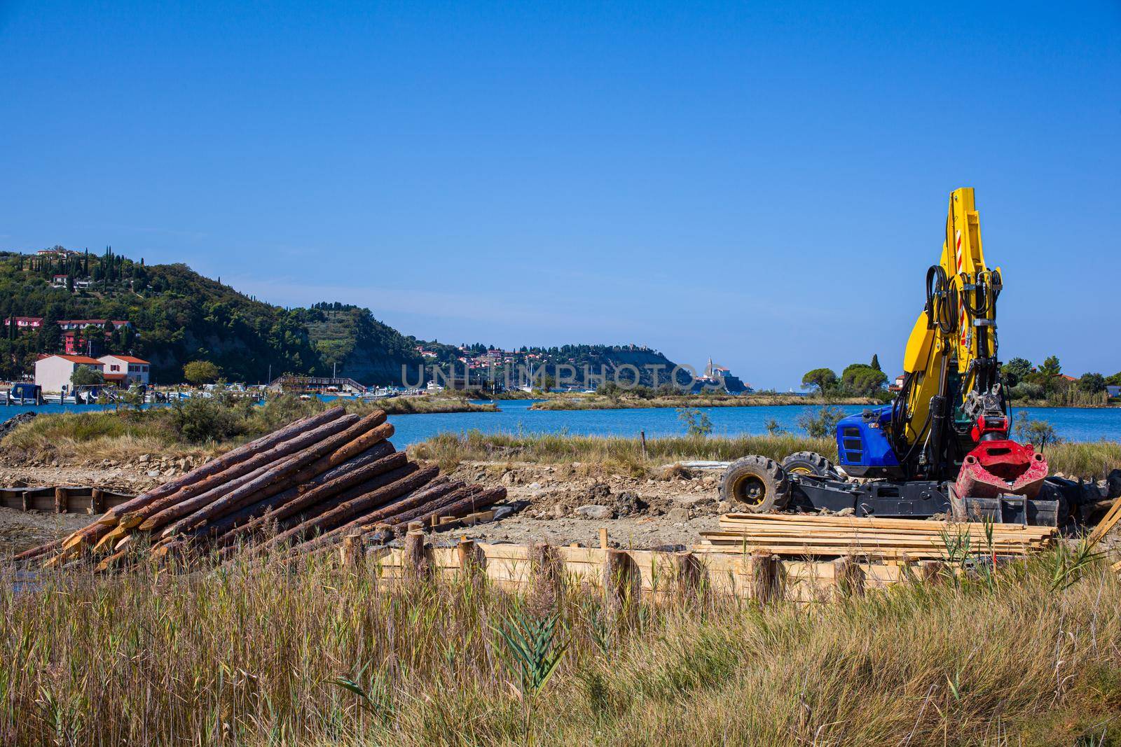 Big powerful excavator digging drainage channel in swamp, Strunjan. Slovenia