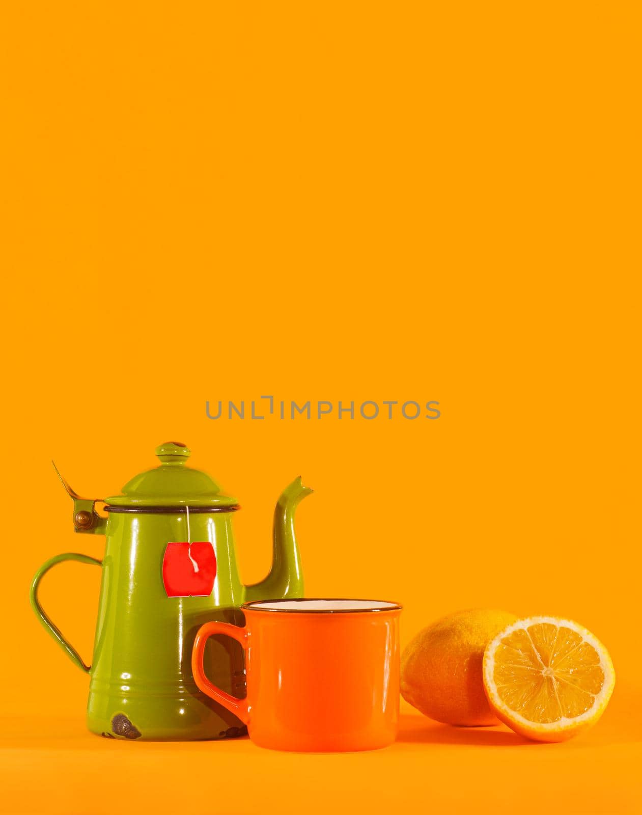 Set of vintage teacup, orange cup and lemon on orange background. Copy space on top