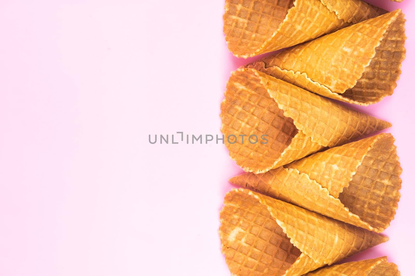 figures from waffle cones for ice cream on a pink background by Lobachad