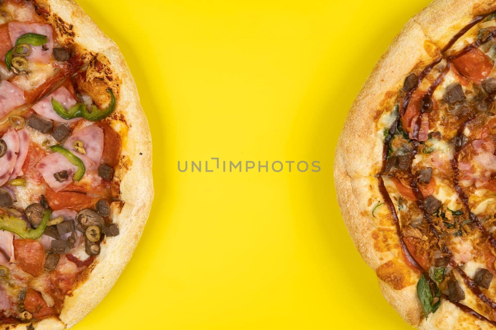 Two different Delicious big pizzas on a yellow background.
