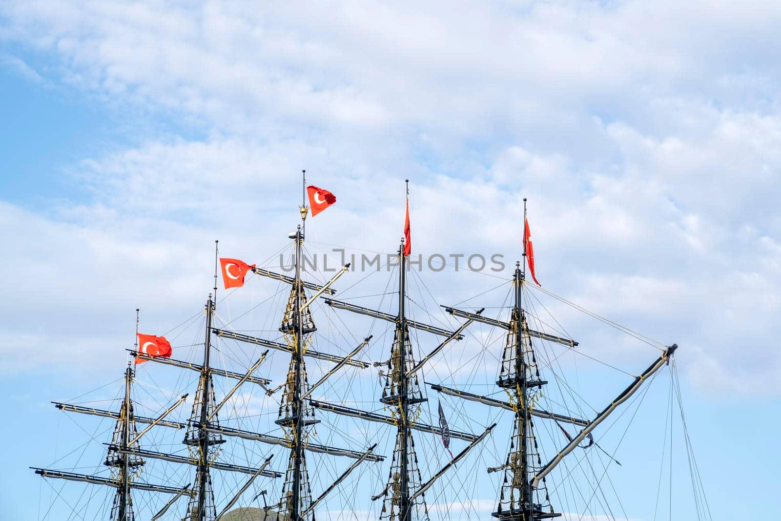 Masts of the ship with turkish flags on the background of the blue sky. The concept of travel and freedom. Copy space