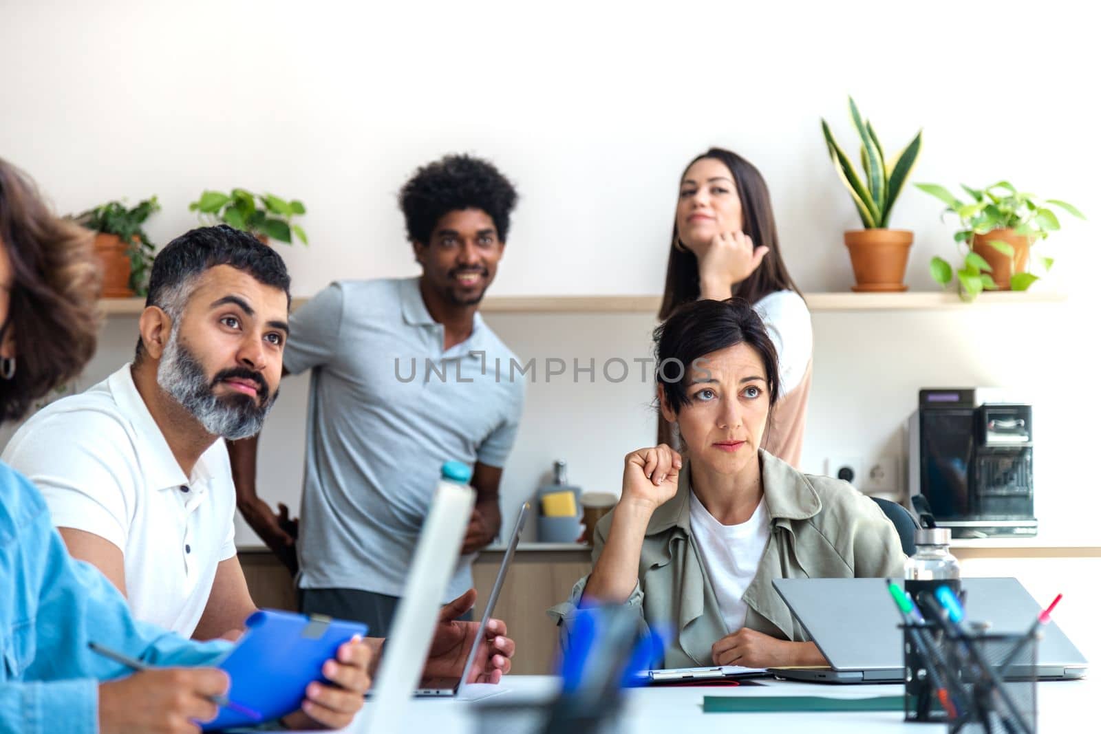 Group of multiracial coworkers at the office looking at something interesting. Coworking space concept.