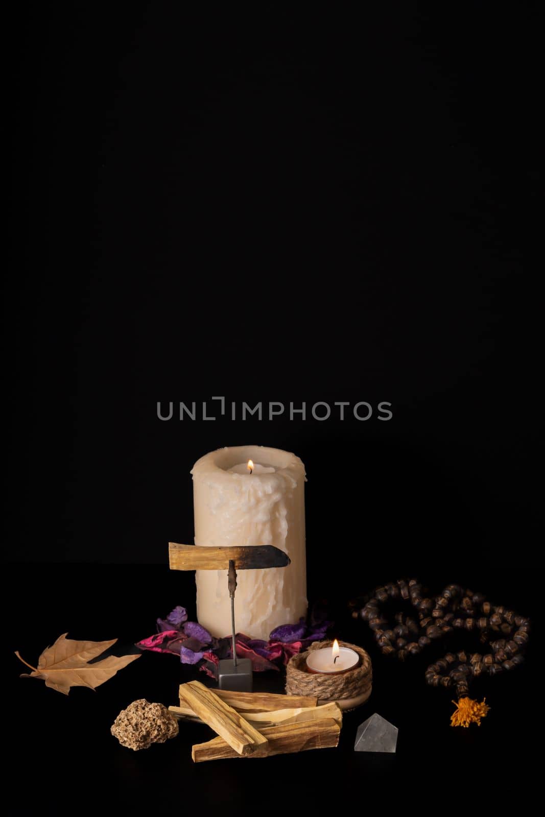 zen image of smoking palo santo,, holy stick with candles and japa-mala on black background
