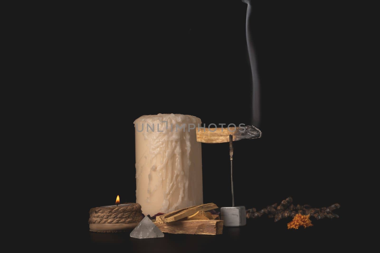 zen image of smoking palo santo,, holy stick with candles and japa-mala on black background