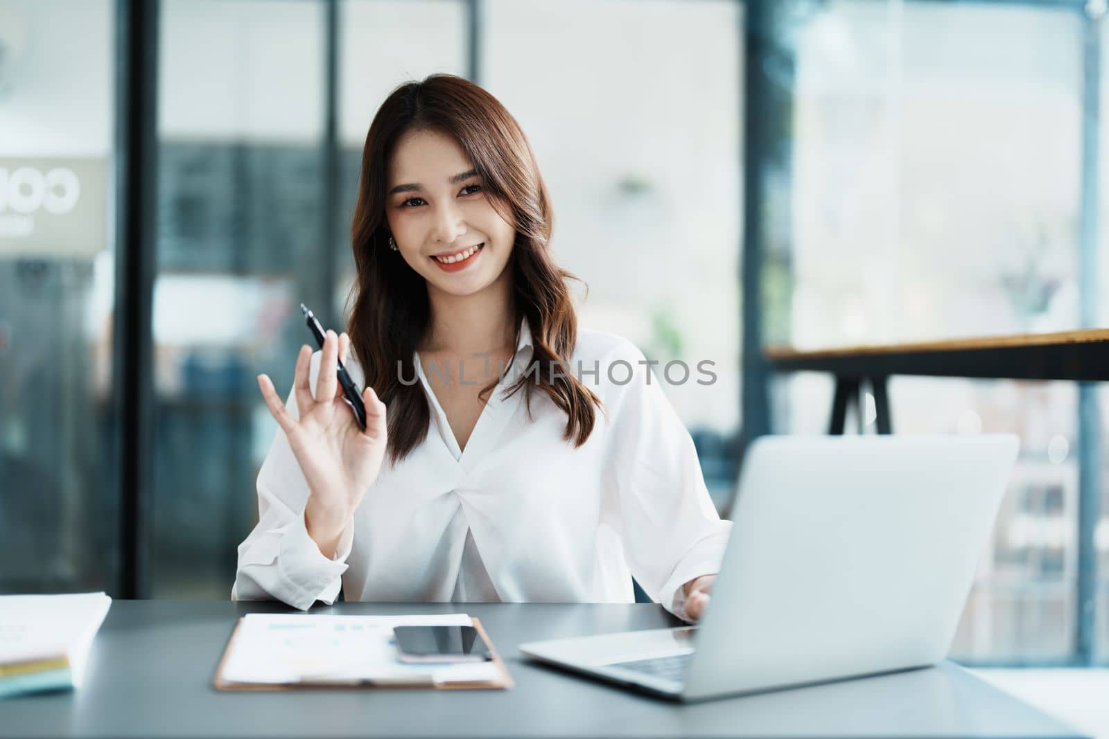 Portrait of a beautiful Asian teenage girl using computer for video conferencing at office.