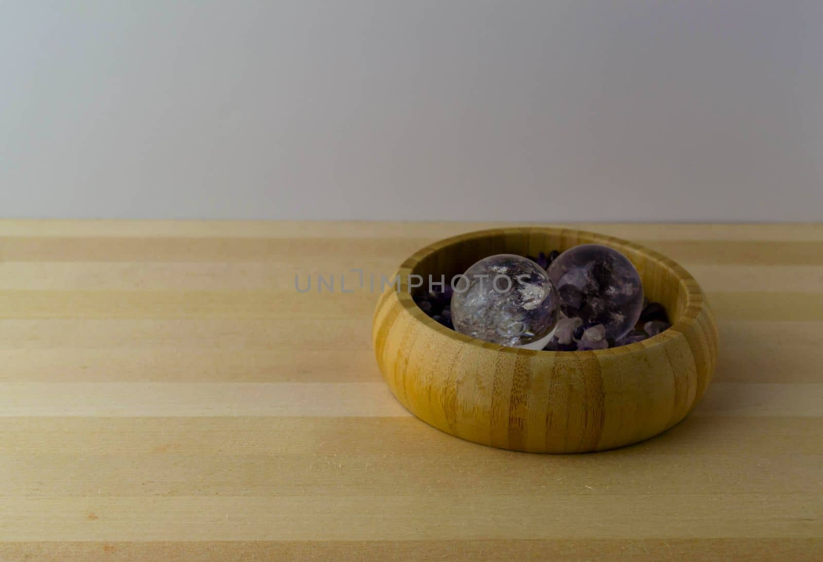 Crystal balls with amethyst stones on a wooden table.