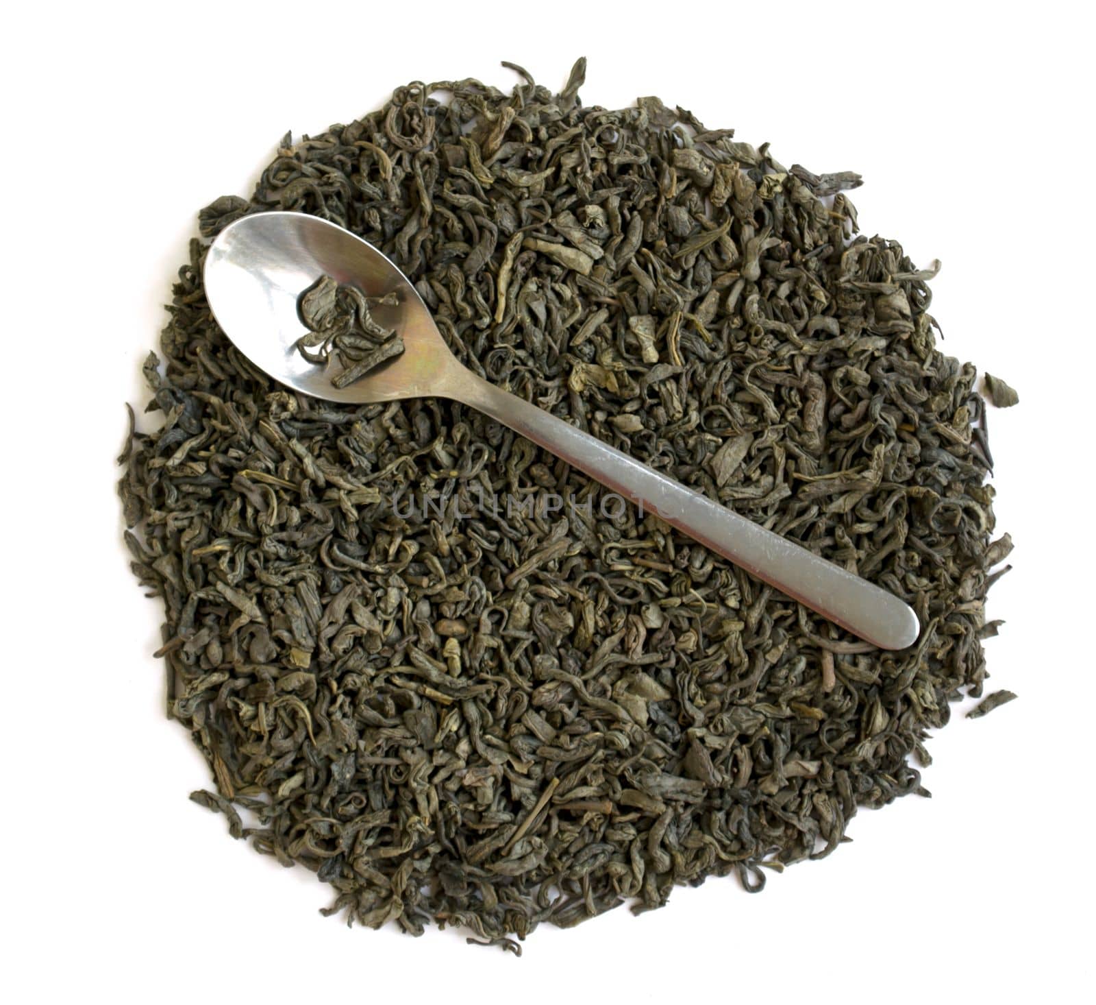 Dried green leaf tea. Green leaf tea and a spoon on a white background close-up.