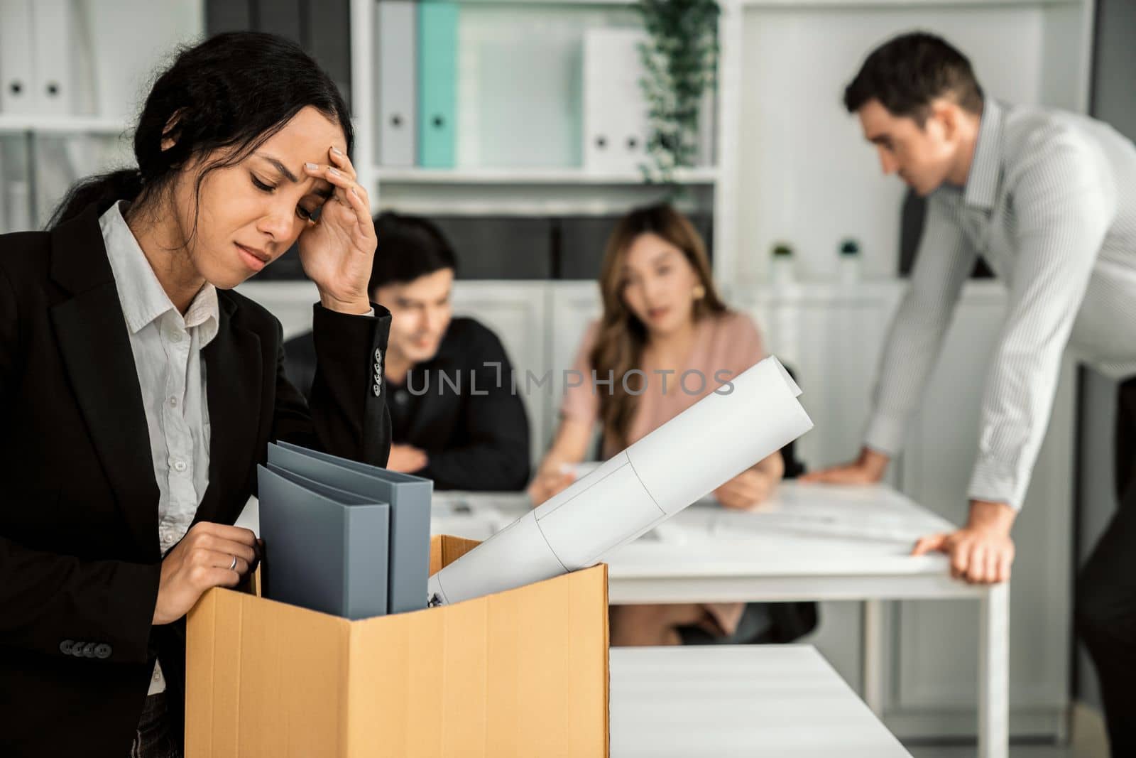 Depressed and disappointed employee packing her belongings after being fired for not being competent. Gossiped by her colleagues behind his back. Layoff due to economic depression.