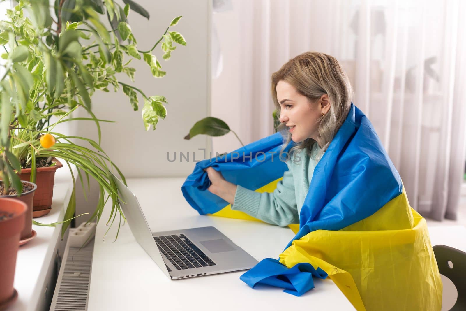 woman with flag of Ukraine and laptop.