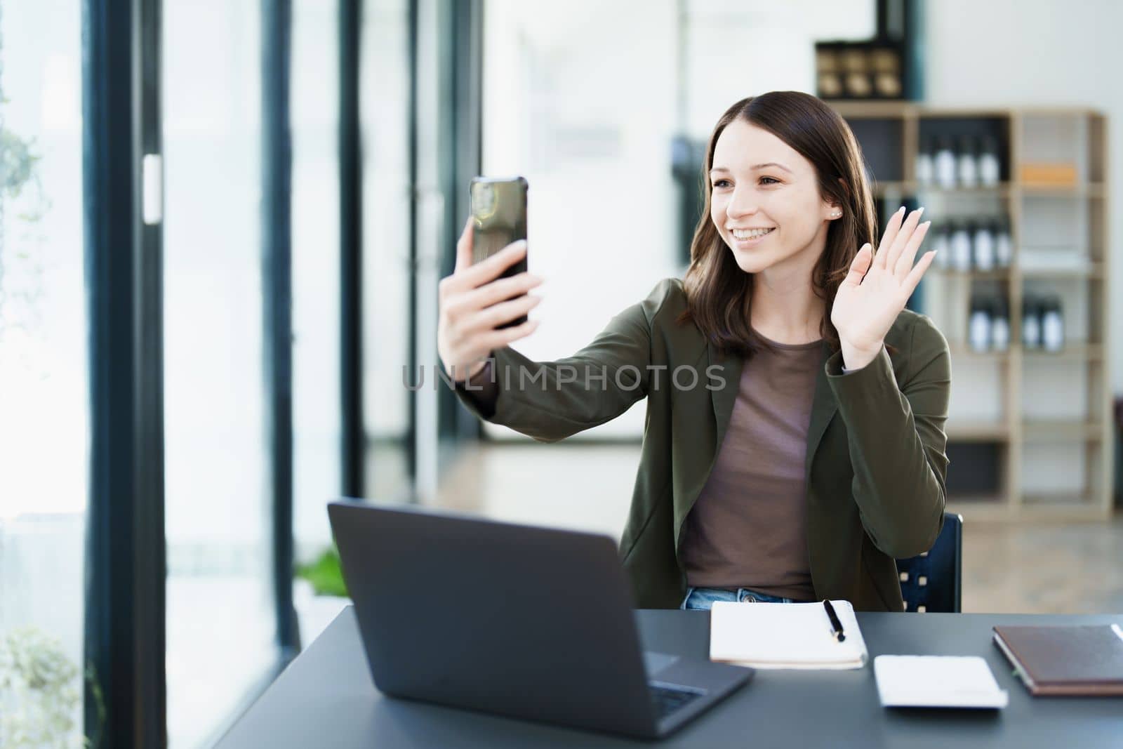 business owner or Asian female marketers are using business phones in office work by Manastrong