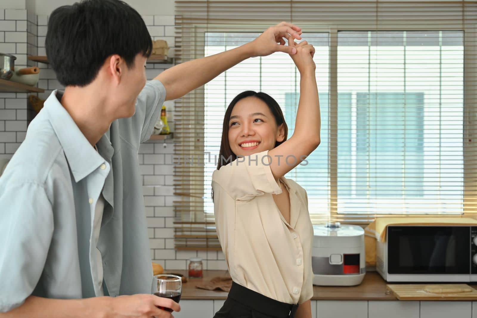 Loving young couple dancing in modern kitchen, spending free weekend time together at home.