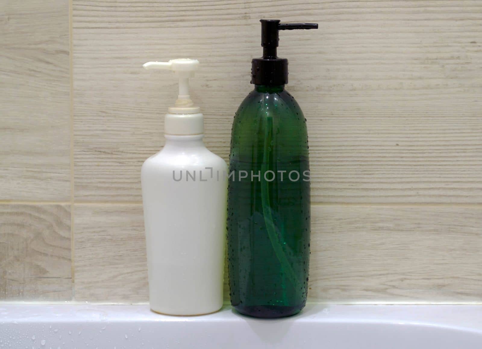 Shampoo bottles. White and green shampoo bottles in the bathroom.