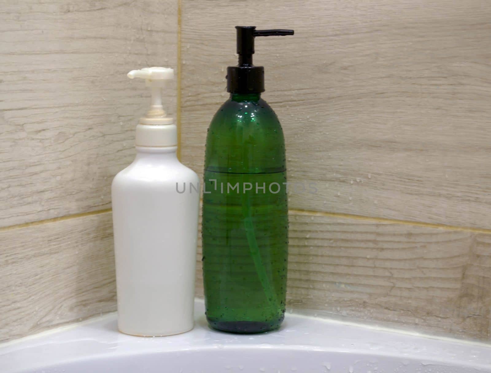 Shampoo bottles. White and green shampoo bottles in the bathroom.