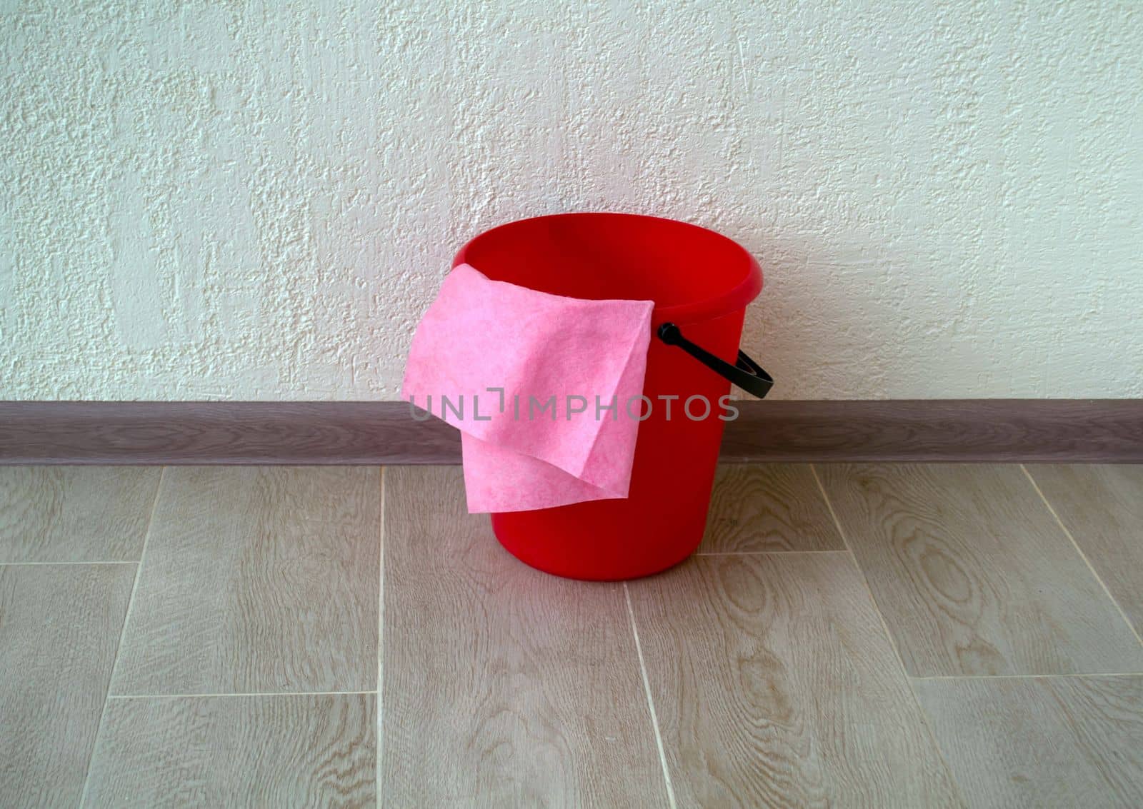 House cleaning. The photo shows a red bucket and a rag.