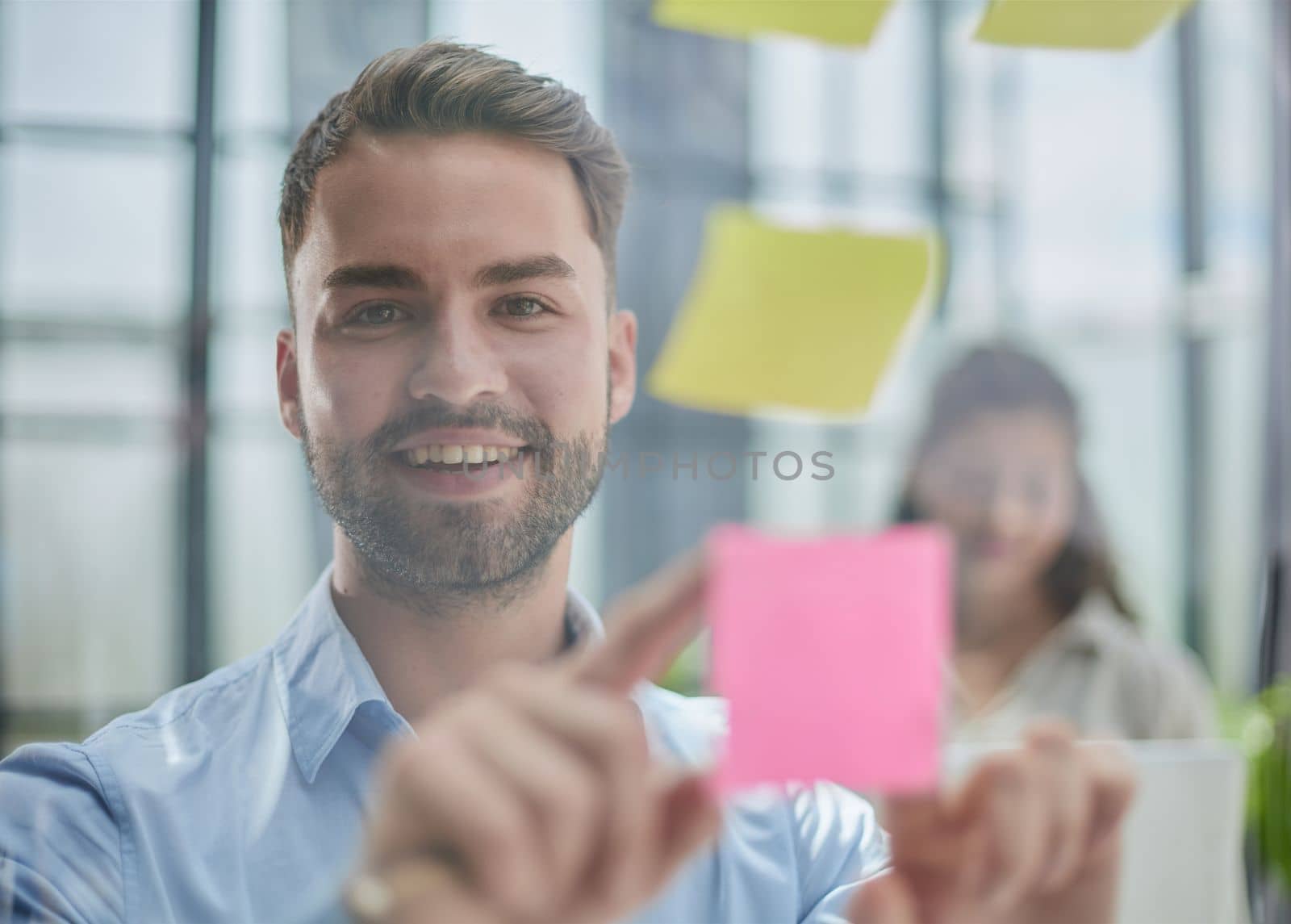 businessman is working on a project. Business man pointing at a note on the glass wall