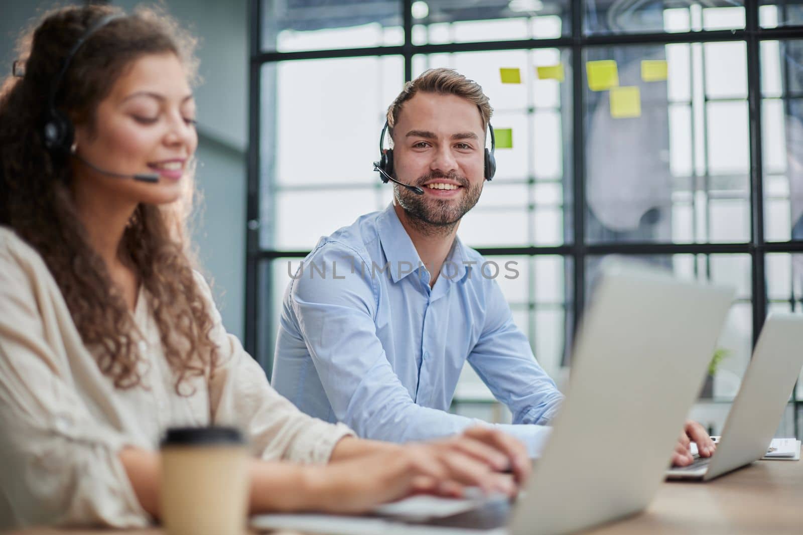 Customer Service Representative With Colleague Working In Office