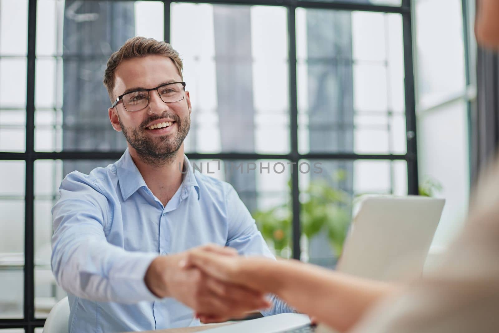 Young business people shake hands in the office. End of a successful meeting. two people