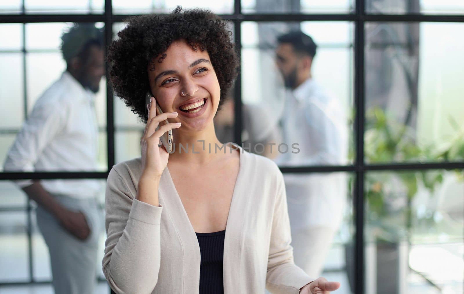 Businesswoman sitting in office, talking on the phone