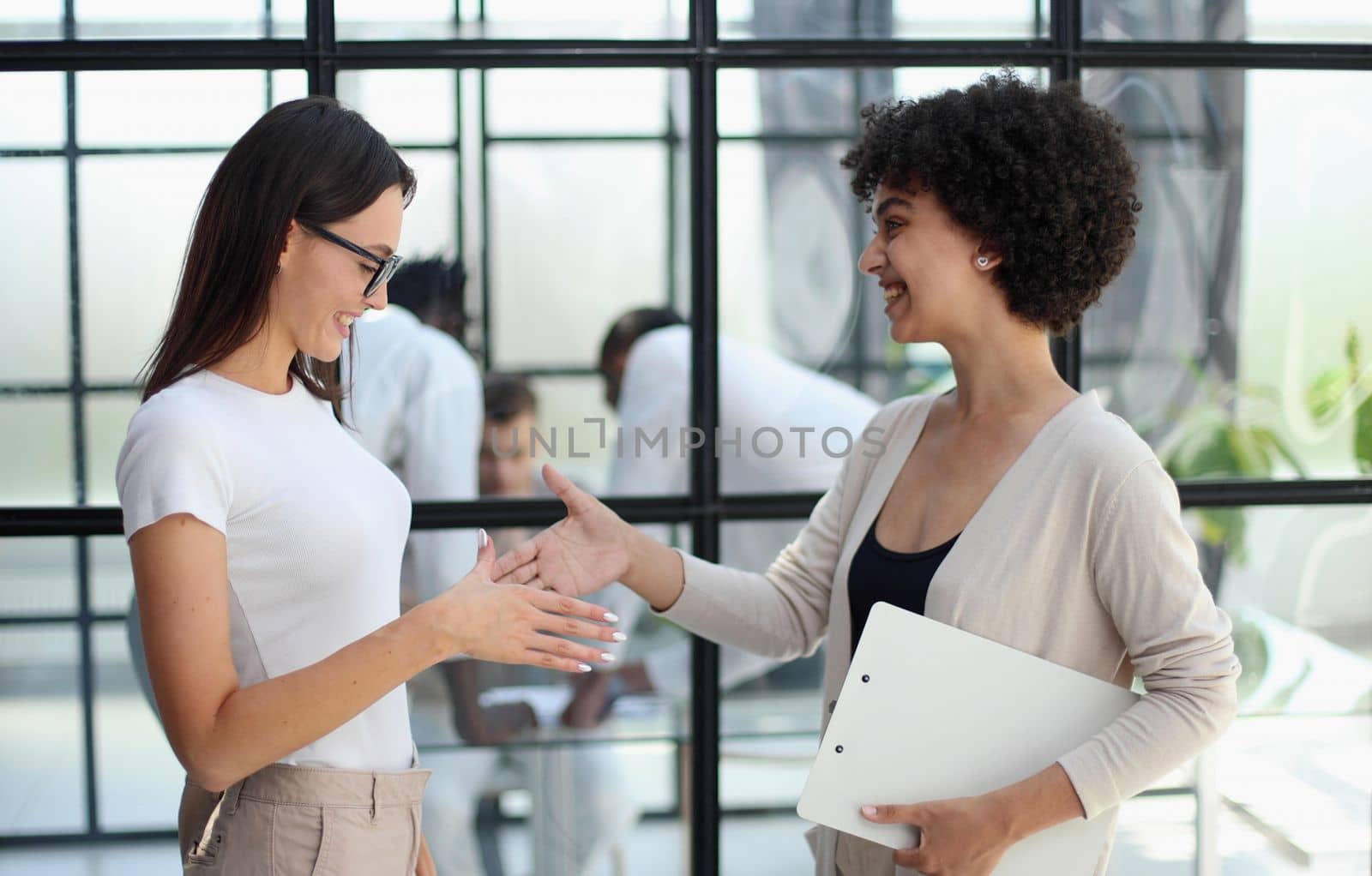 Two women analyzing documents office. Woman executives at work in office discussing some paperwork. by Prosto