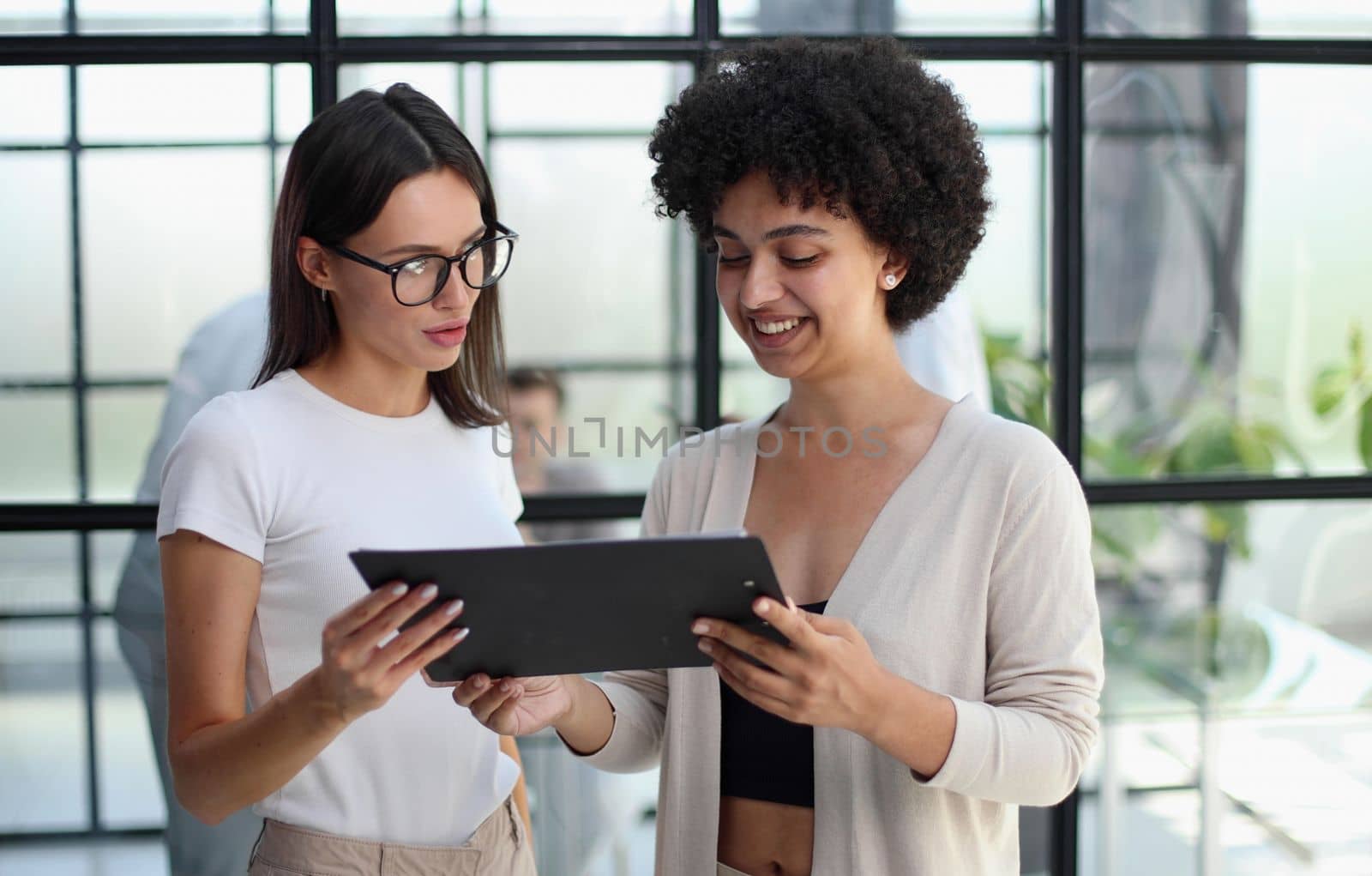 Two women analyzing documents office. Woman executives at work in office discussing some paperwork. by Prosto