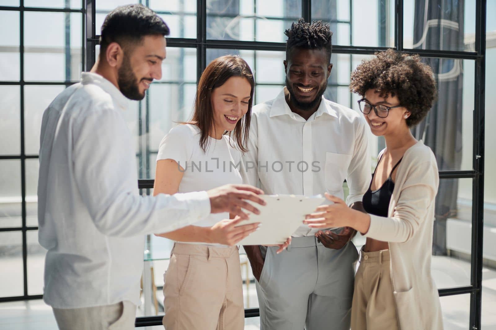 Happy young female employee discussing online project, showing computer presentation to skilled team leader in eyeglasses. Friendly diverse colleagues working in pairs on laptop, using applications.