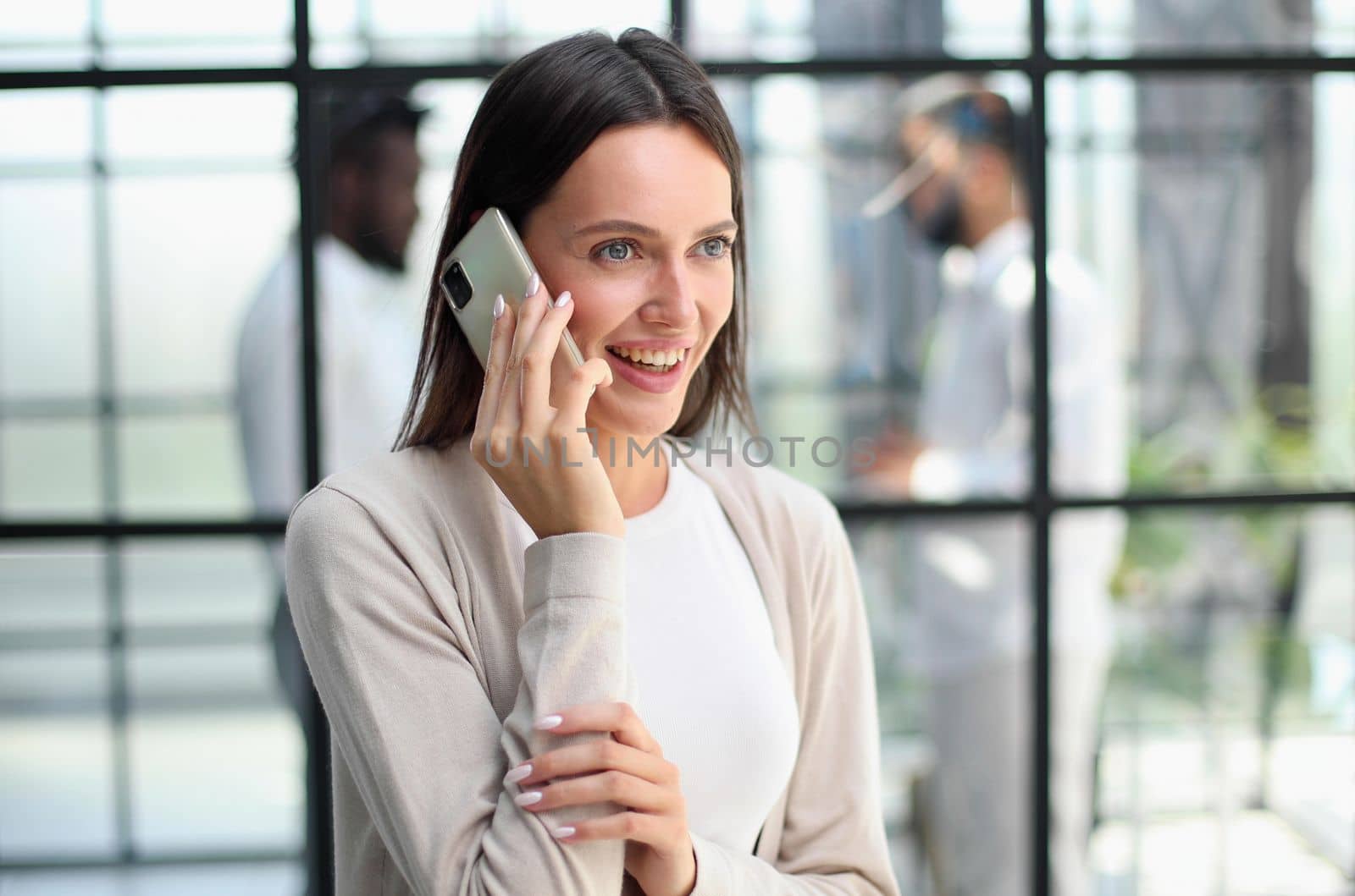 Businesswoman sitting in office, talking on the phone