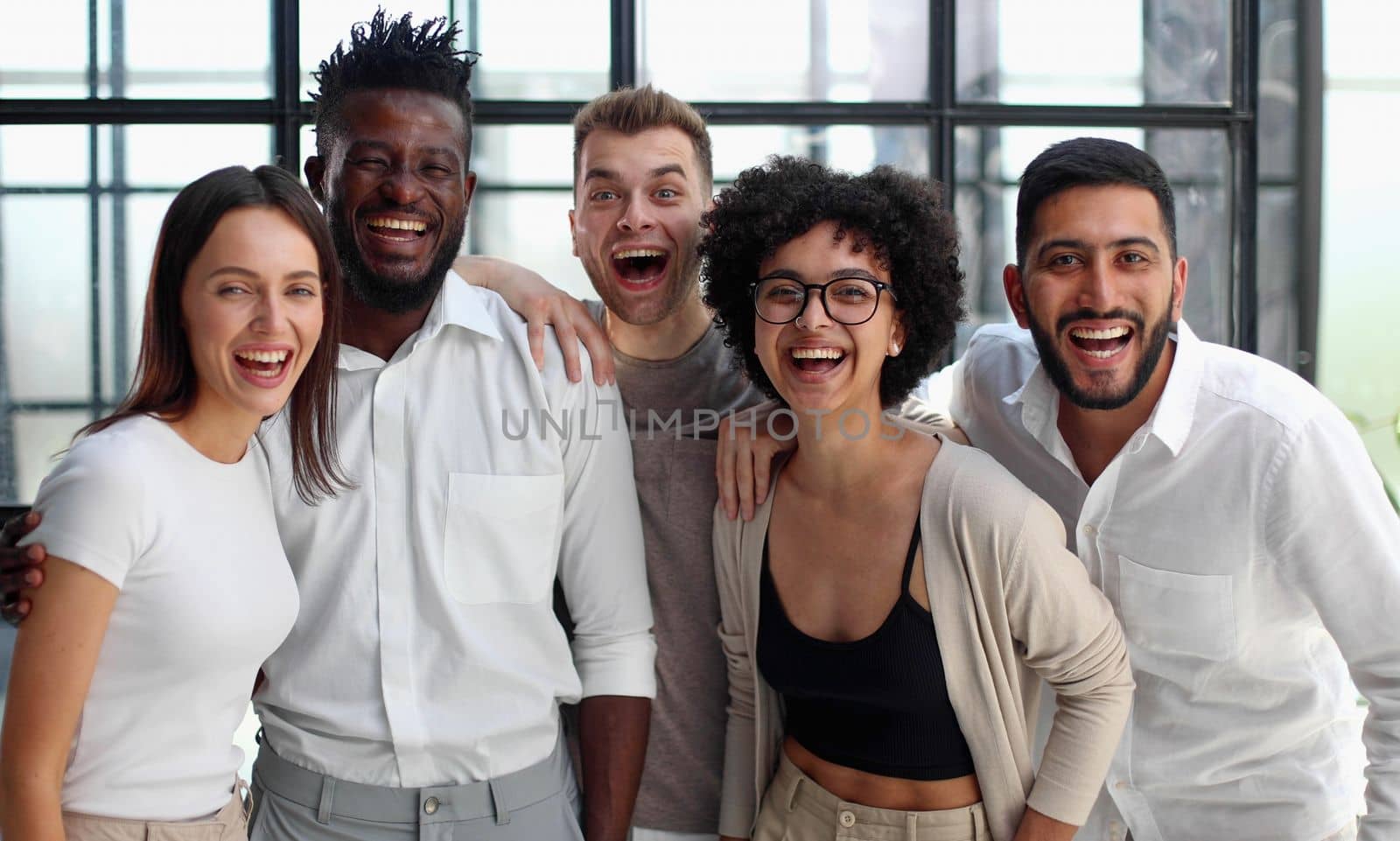 Portrait of successful creative business team looking at camera and smiling. Diverse business people standing together at startup.