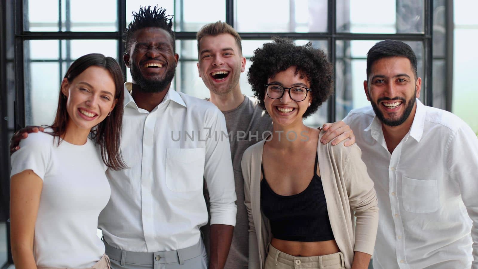 Portrait of successful creative business team looking at camera and smiling. Diverse business people standing together at startup.