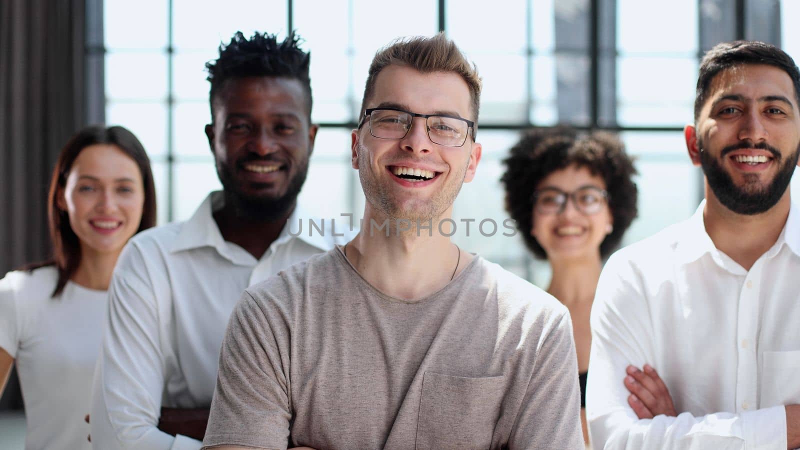 Portrait of successful creative business team looking at camera and smiling. Diverse business people standing together at startup.