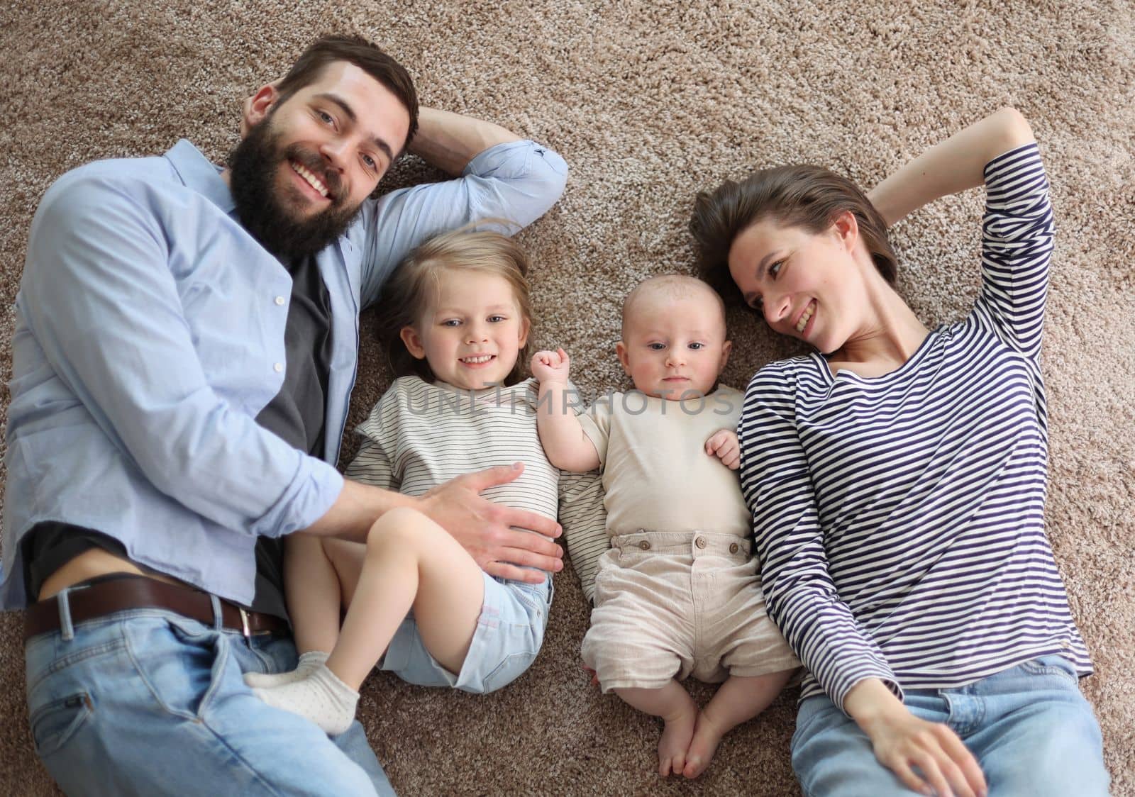 happy family mother father and kids at home. laying