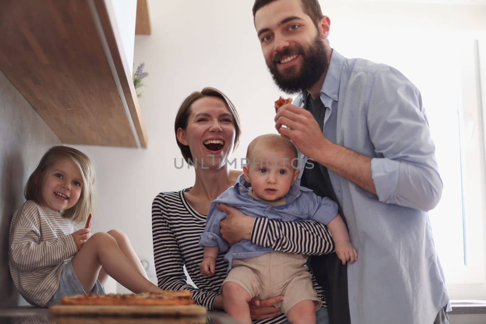 Young family with daughter and son in the kitchen