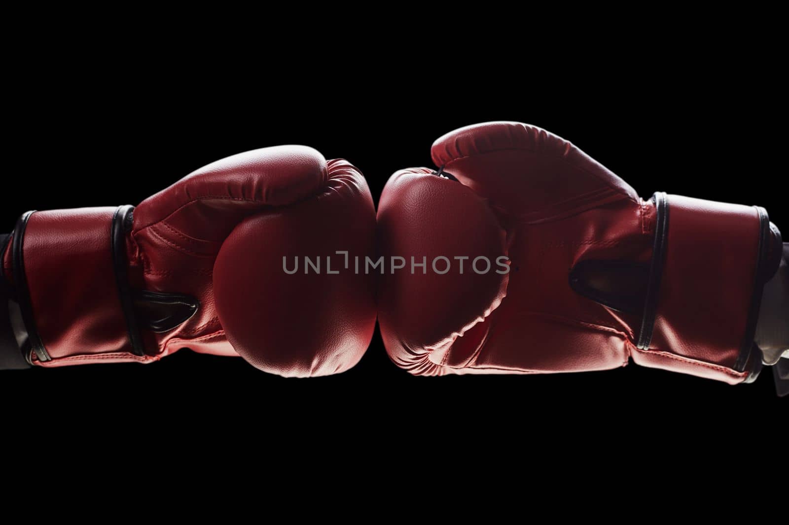 Two men's hands in boxing gloves. The concept of confrontation. Photo on a black background by Prosto