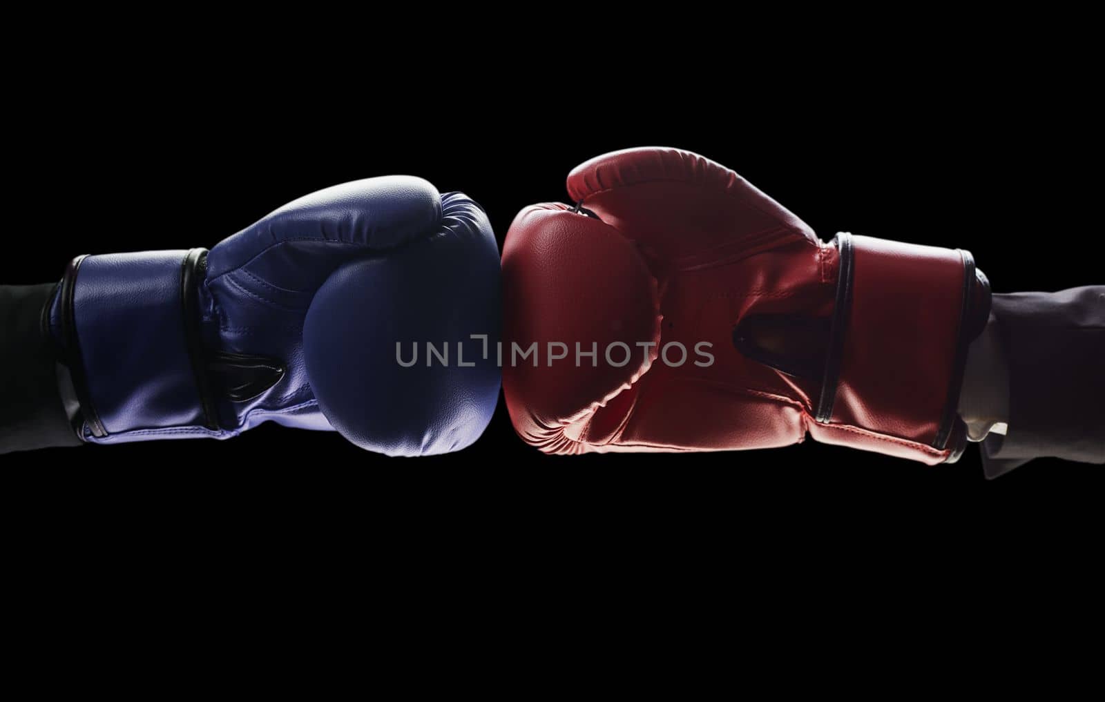 Two men's hands in boxing gloves. The concept of confrontation. Photo on a black background