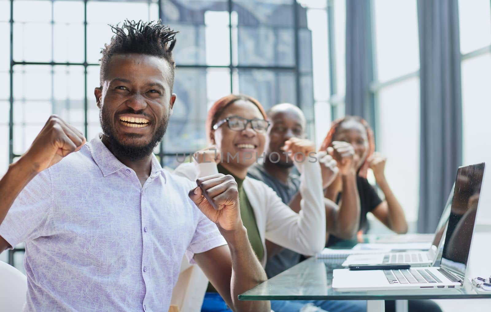 Happy young African-American man and his team in background