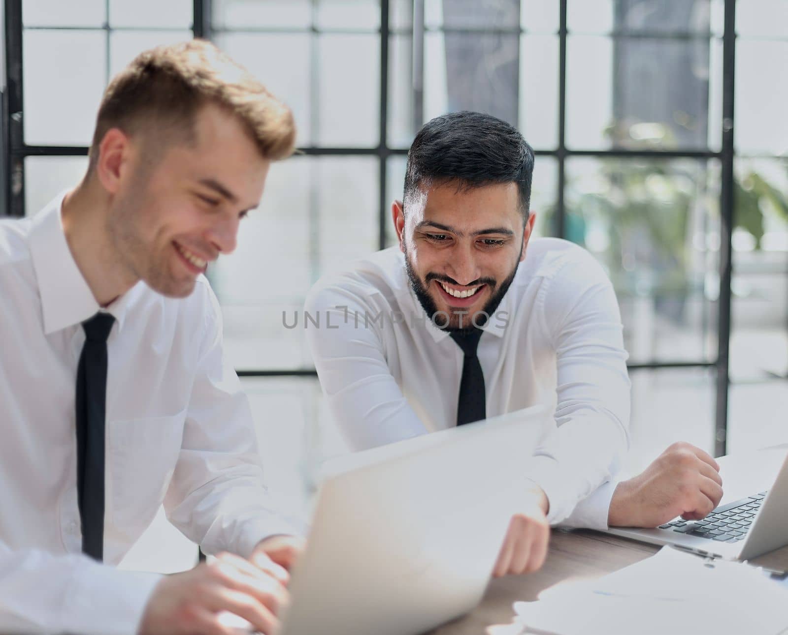 Discussing the problem. Two confident business man discussing something on the computer