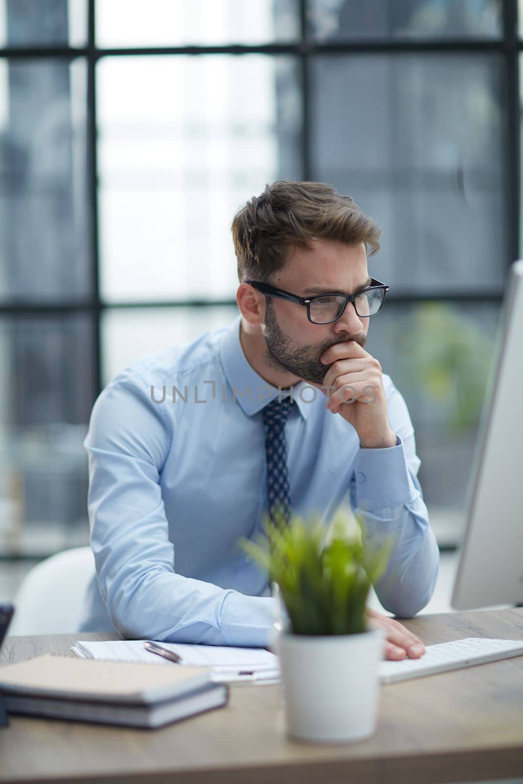 Young cheerful businessman working at office