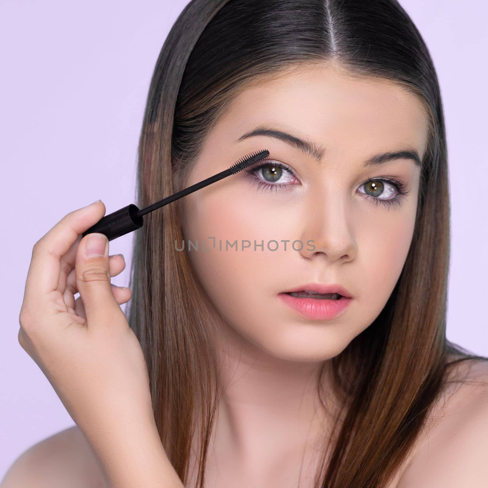 Closeup portrait of young charming applying makeup eyeshadow with brush. by biancoblue