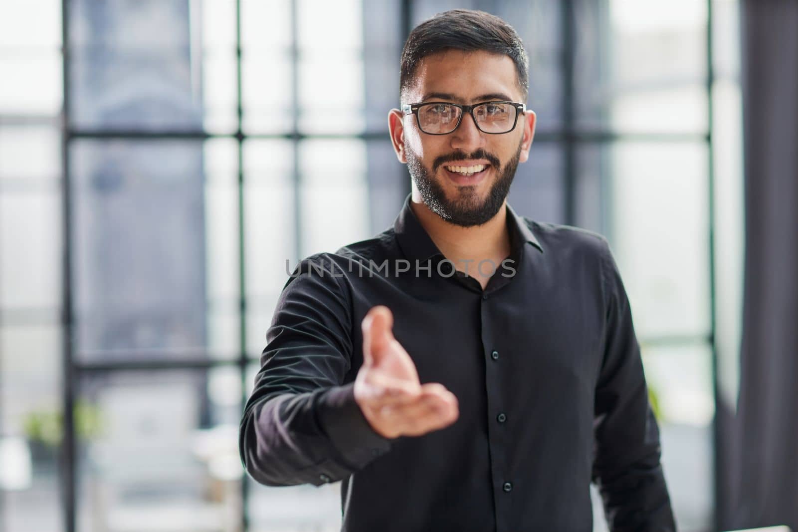 smiling businessman reaching out for a handshake
