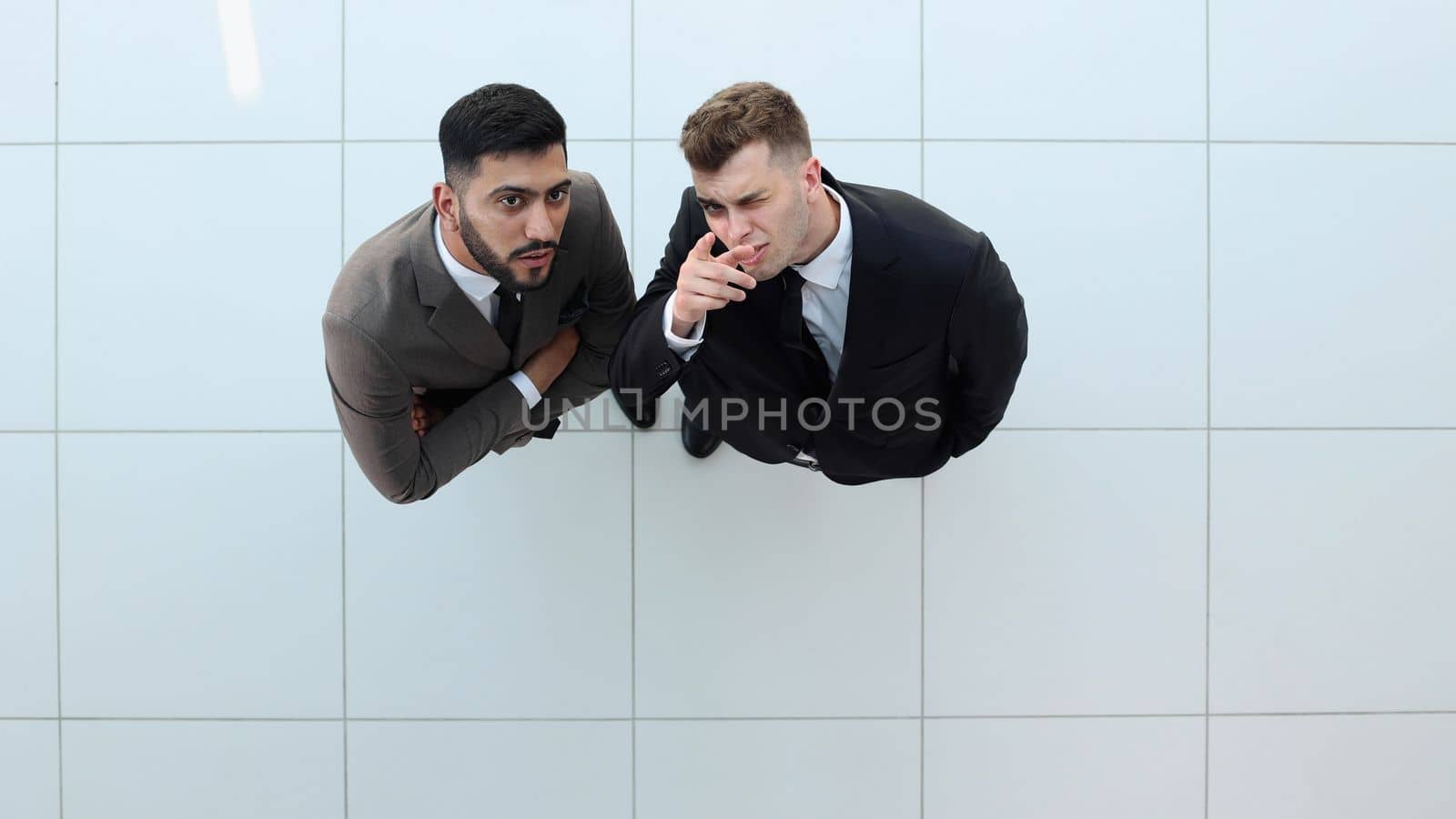 Portrait of two concentrated businessmen partners dressed in formal suit walking and having conversation during working meeting